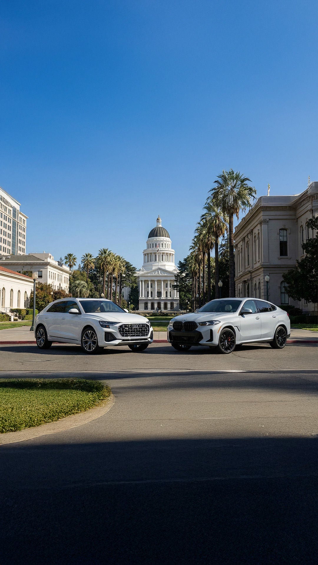 Audi Q8 vs BMW X6 parked nose to nose out front of the Sacramento state capitol building