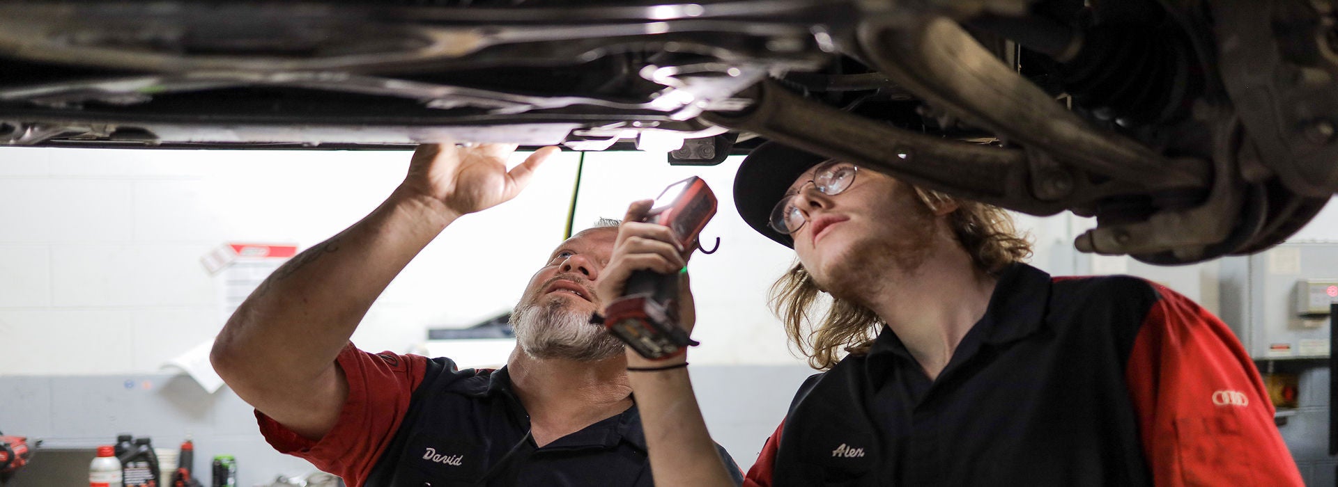 Service technician servicing a tire with another technician.