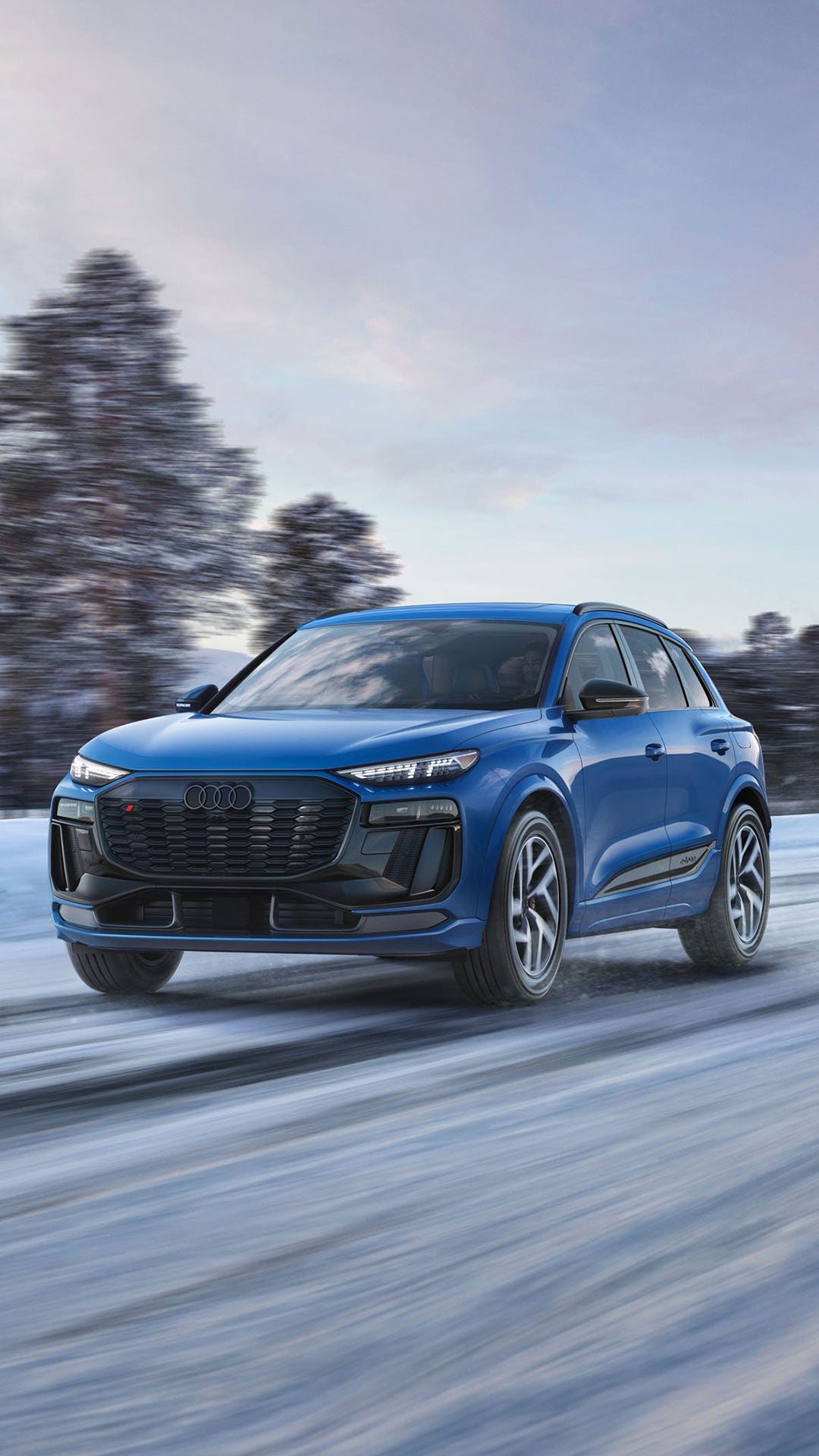 Three-quarter front view of a blue Audi SQ6 e-tron accelerating.