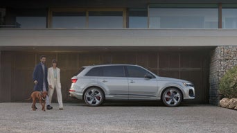 Audi Q7 parked with family walking next to it