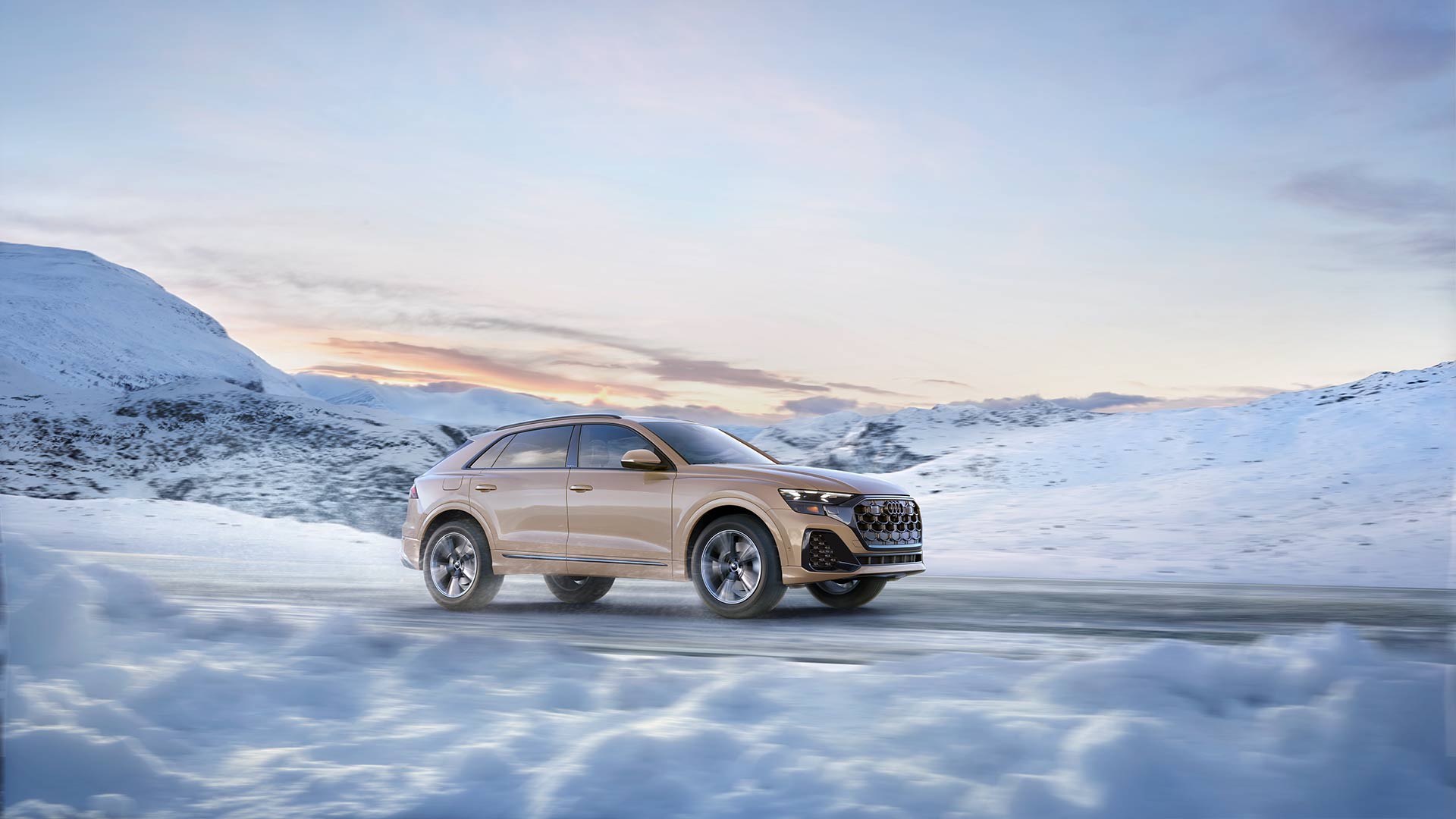 Side view of an Audi Q8 driving on a snowy road.