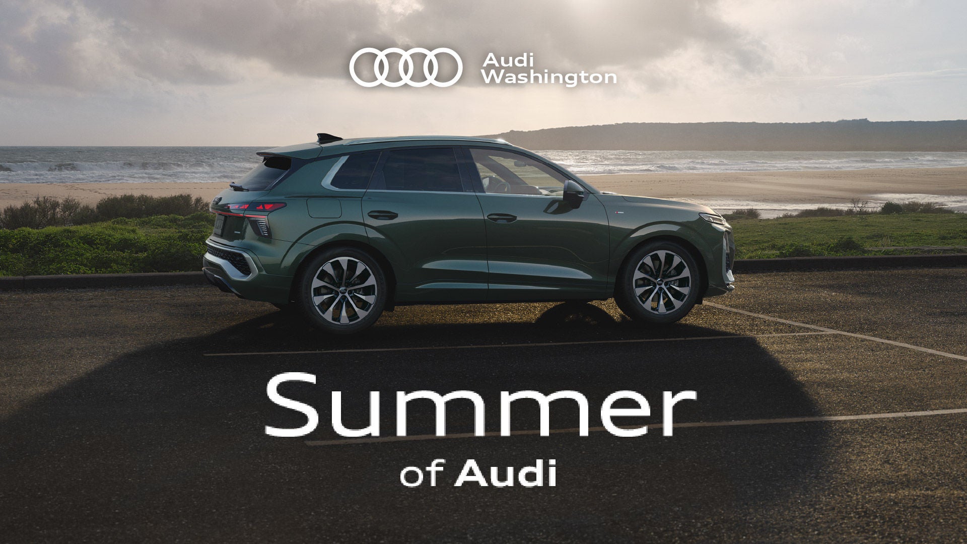 Four Audi vehicles parked side by side with a city skyline in the background.