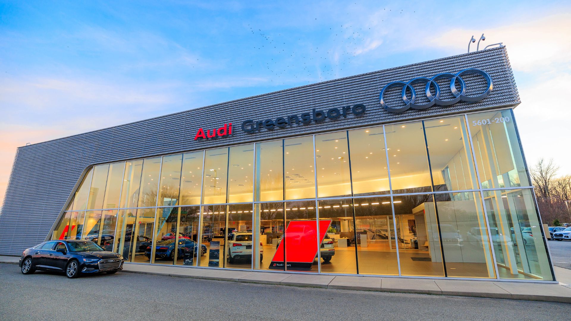 Audi Greensboro dealership building with a car parked in front