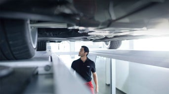 Audi mechanic looking underneath a vehicle.