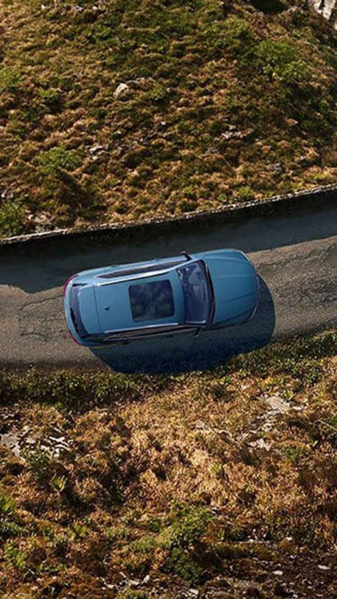 Bird's eye view of an Audi vehicle driving down a winding road.