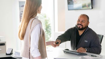 Audi employee handing keys over to a customer. 