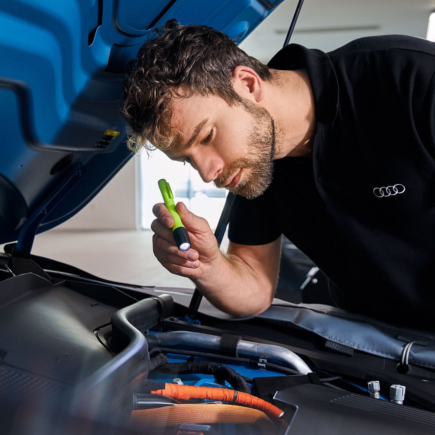 Audi service technician servicing a vehicle.