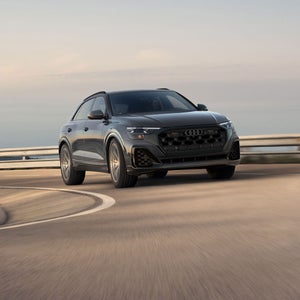 Three-quarter front view of the Audi SQ8 accelerating on a mountainside road.