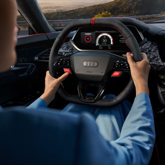 Over-the-shoulder of a person driving the Audi RS e-tron GT. 