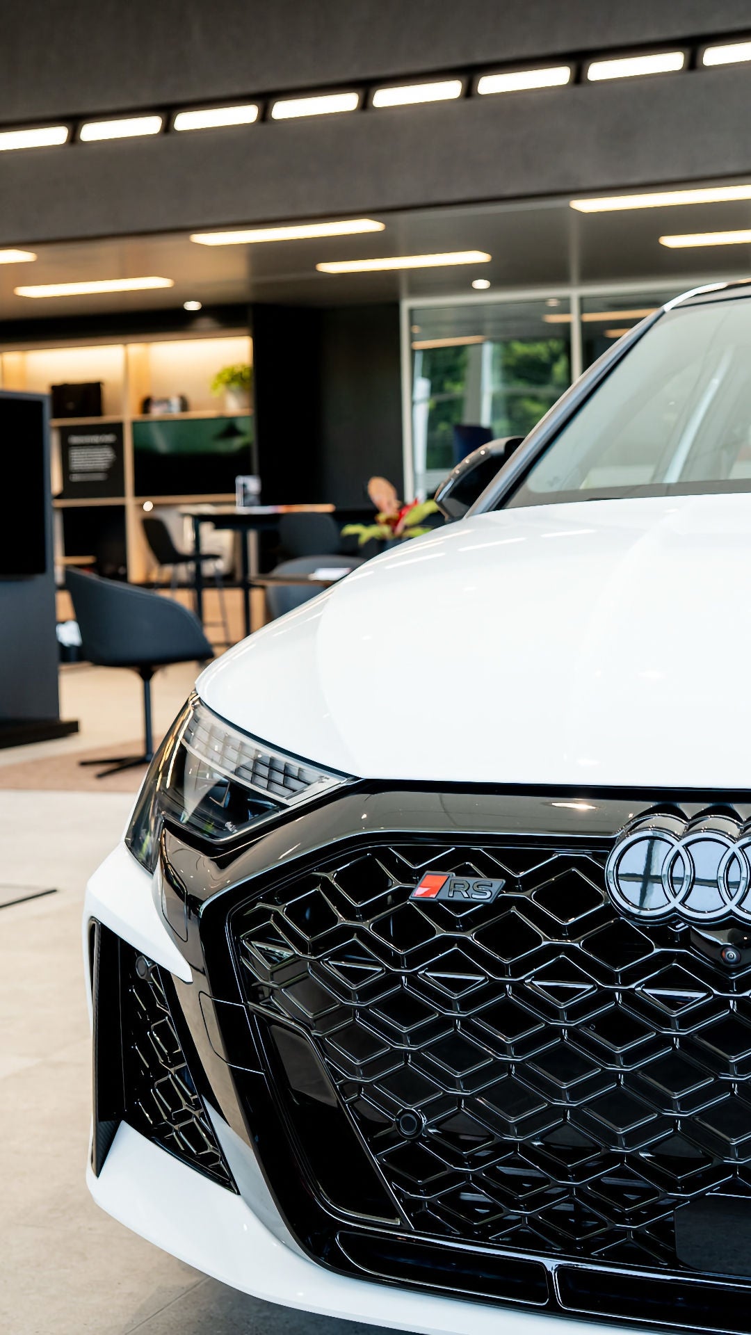 Left profile view of an Audi vehicle parked in the showroom.