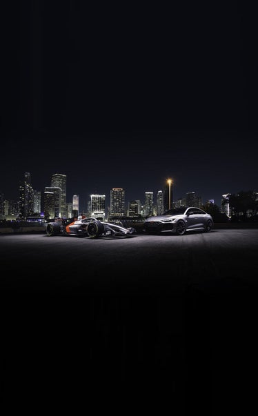 Audi RS5 hot lap car against the Miami skyline at night