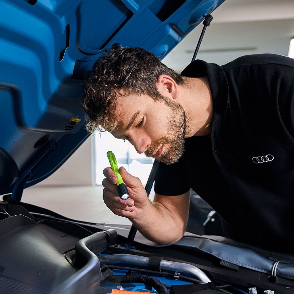 An Audi technician servicing a vehicle.