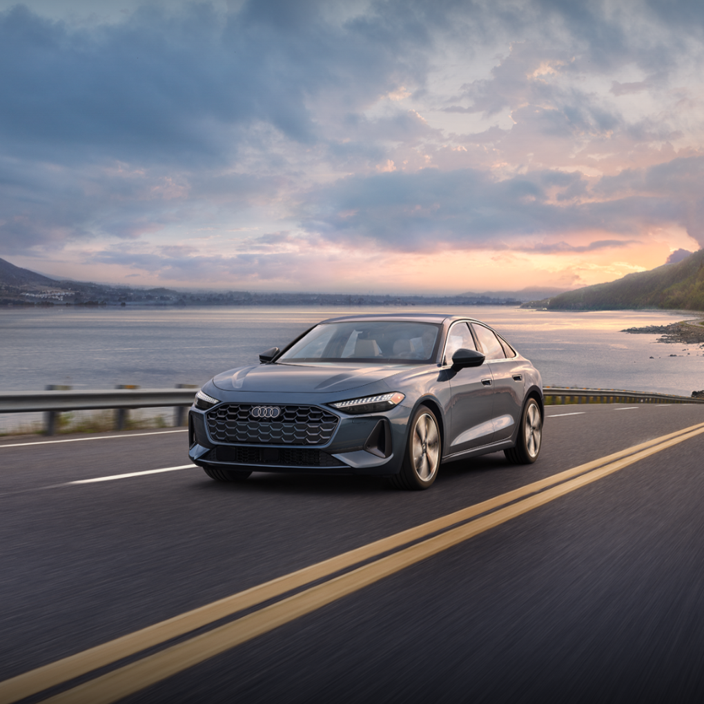 Left profile view of an Audi A5 driving on a highway.