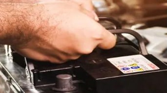 Service technician servicing car battery.