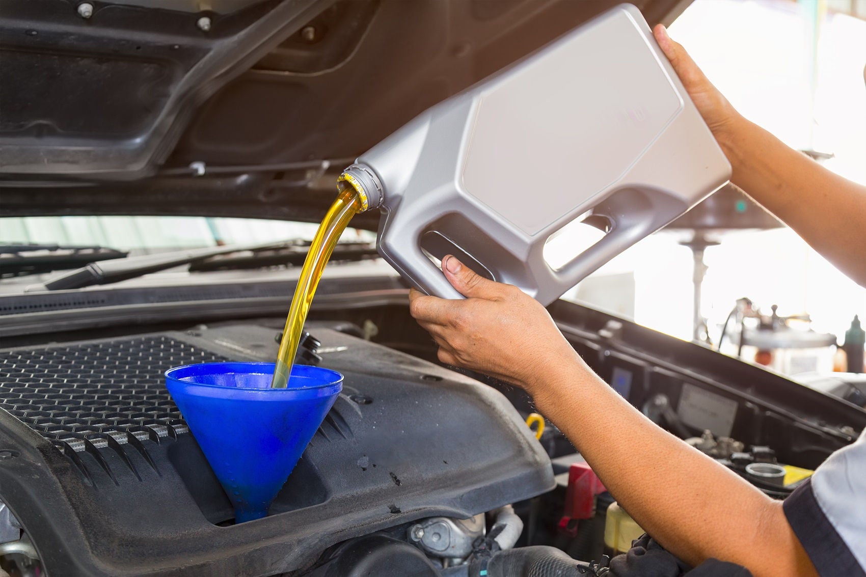service technician pouring in car oil