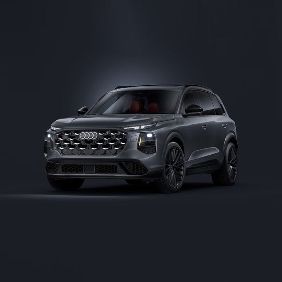 Three-quarter front view of the Audi SQ7 with the headlights lit up.