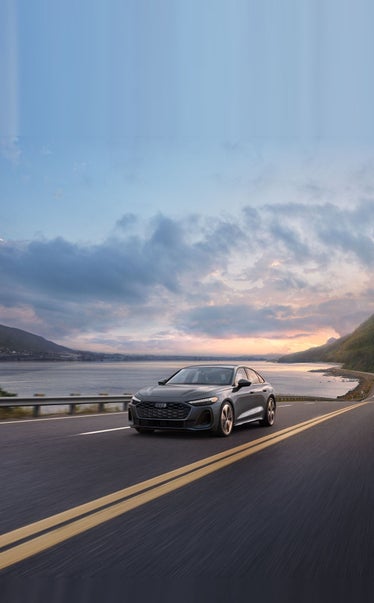 2026 Audi A5, front three-quarter on a coastal road